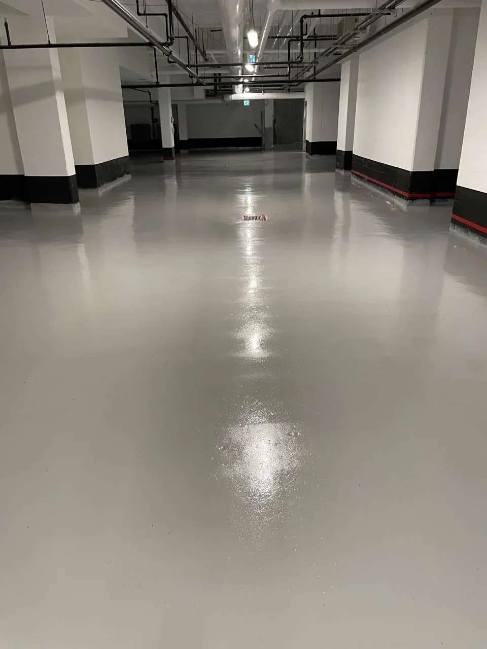 Grey coated surface around columns and a floor drain at Allenbury Gardens